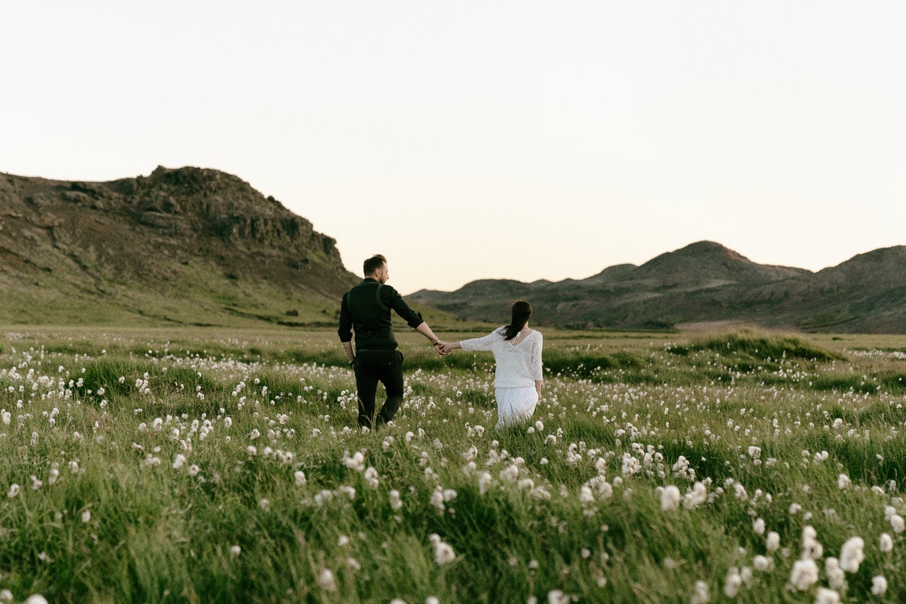 Hochzeitspaar läuft über Wiese