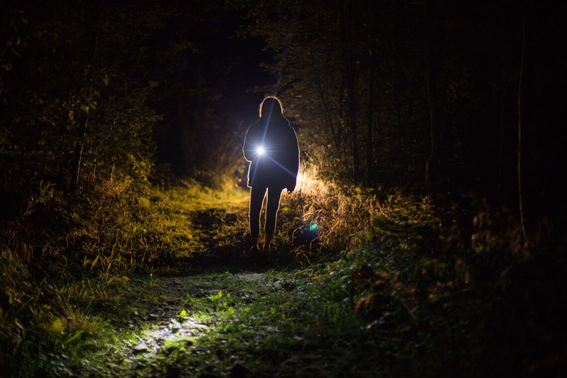 Frau mit Taschenlampe im Freien